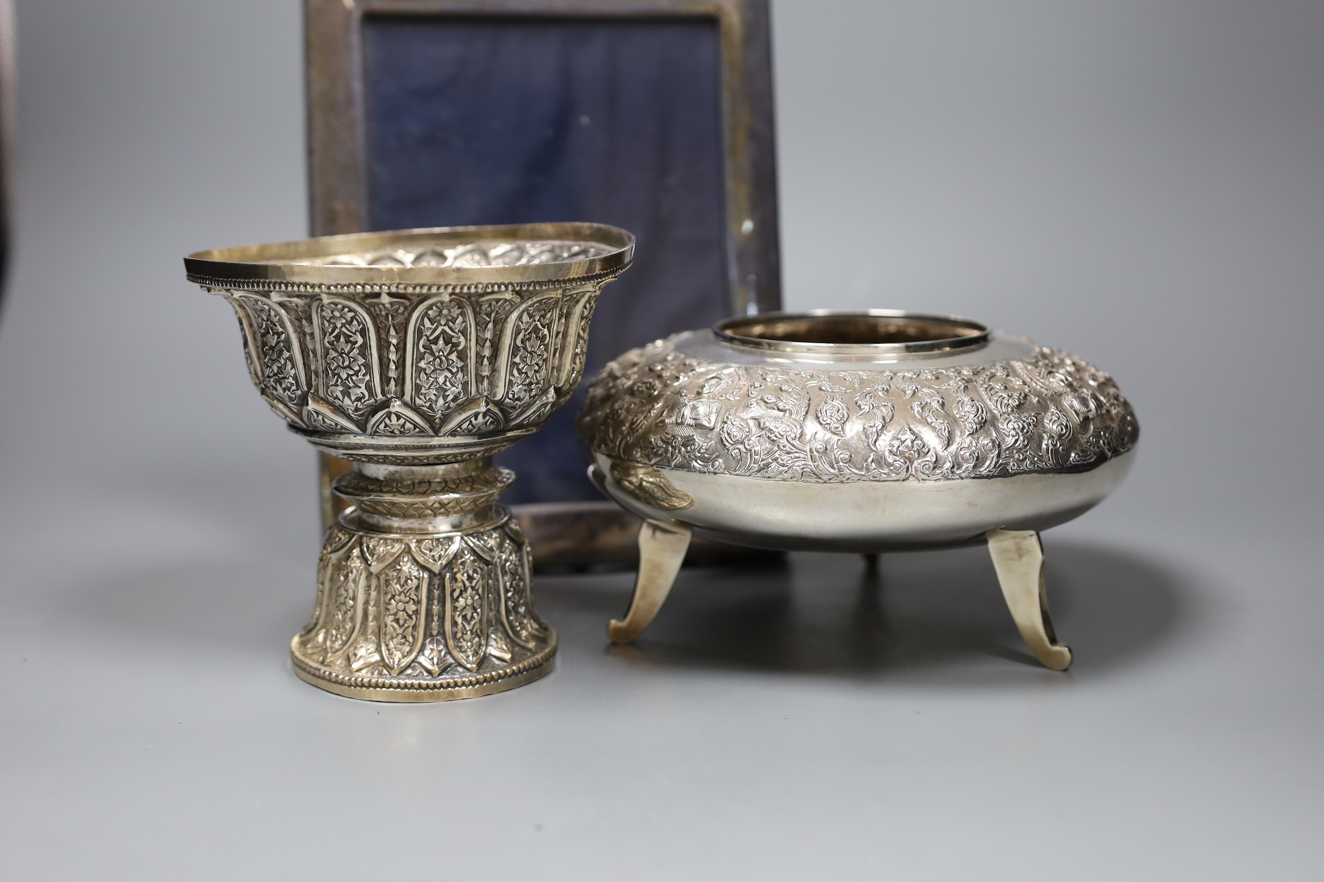 Six assorted embossed Thai white metal bowls, largest 18cm diam., and a silver photograph frame